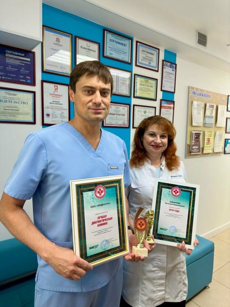 Врачи клиники с наградами у стены с сертификатами